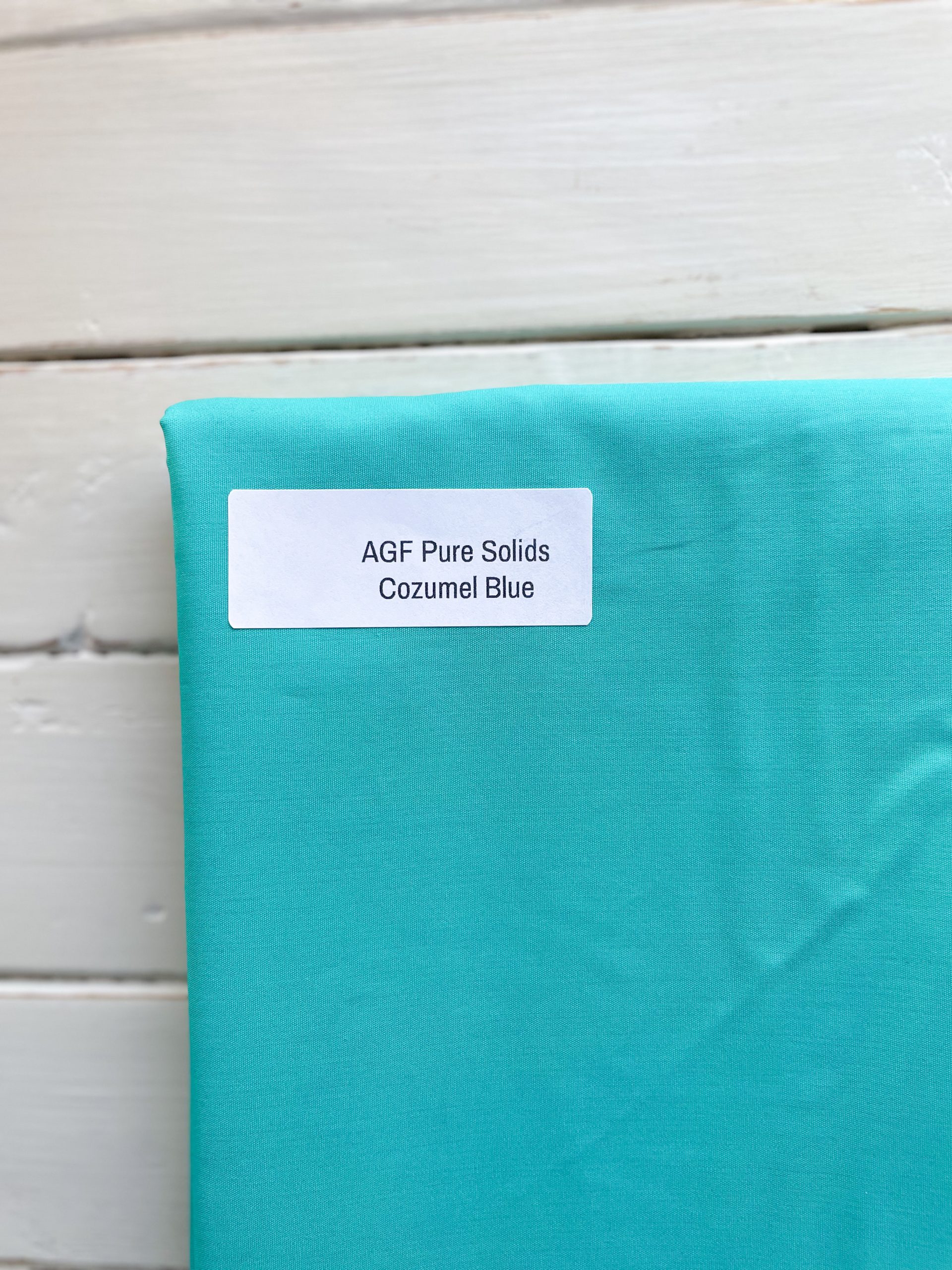 Cozumel Blue fabric on wooden surface.