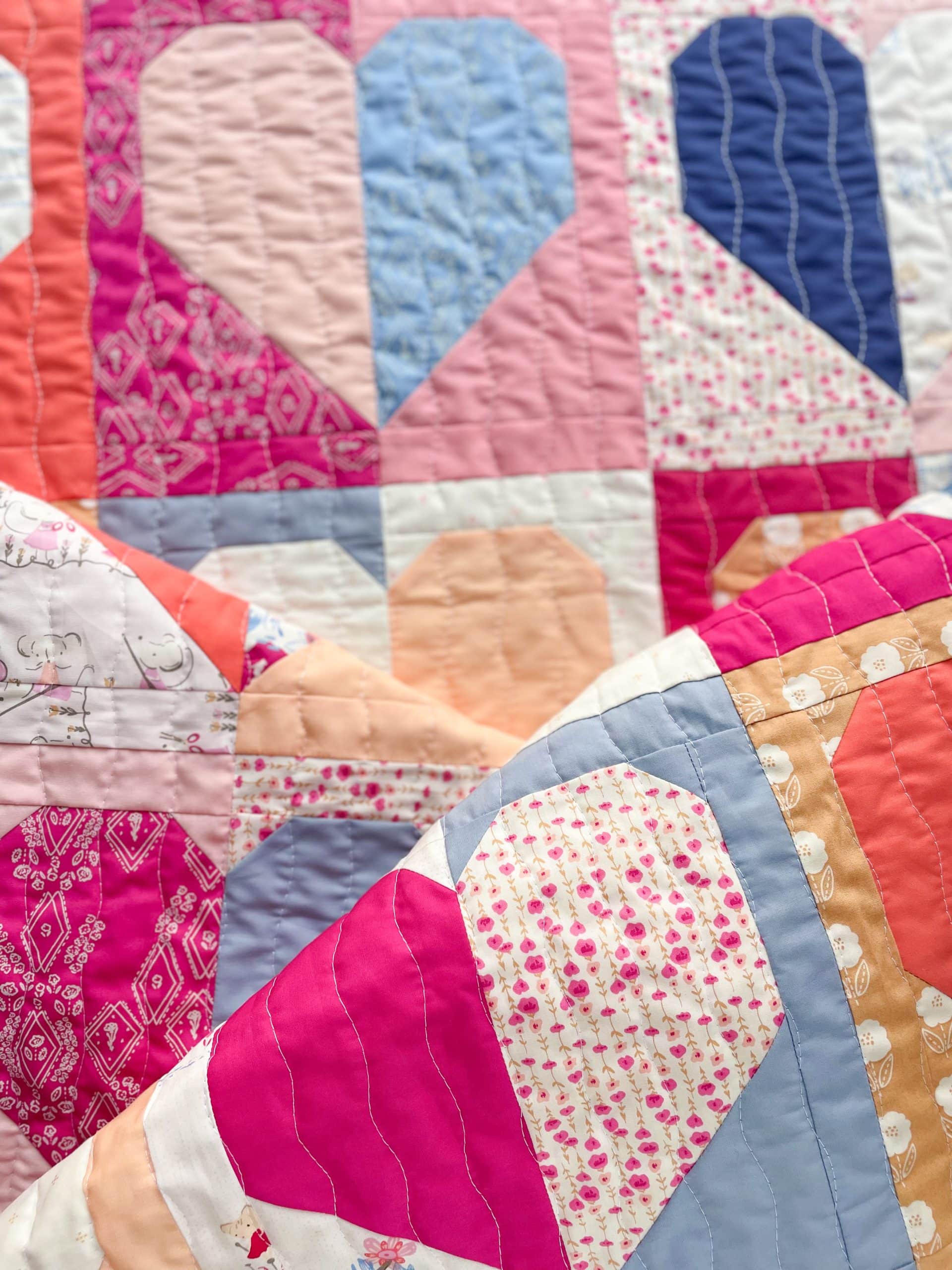 Colorful heart-patterned quilt with various fabrics.