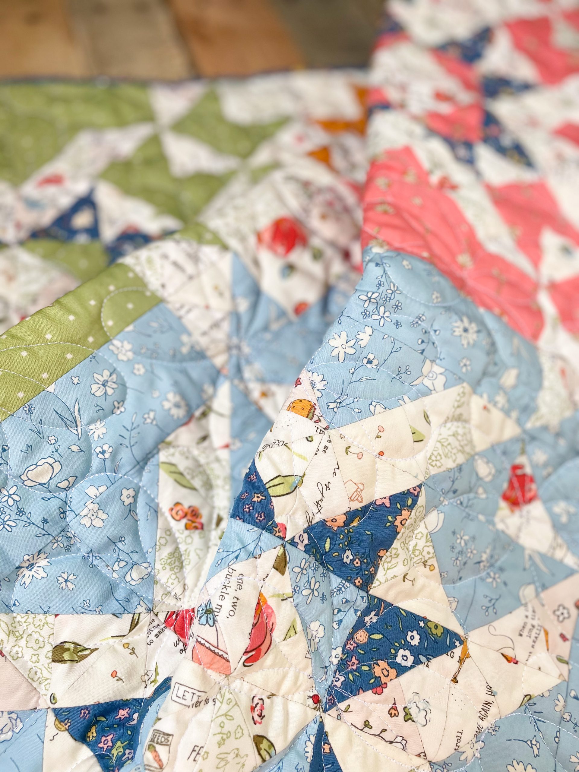 Colorful quilt with floral and geometric patterns.
