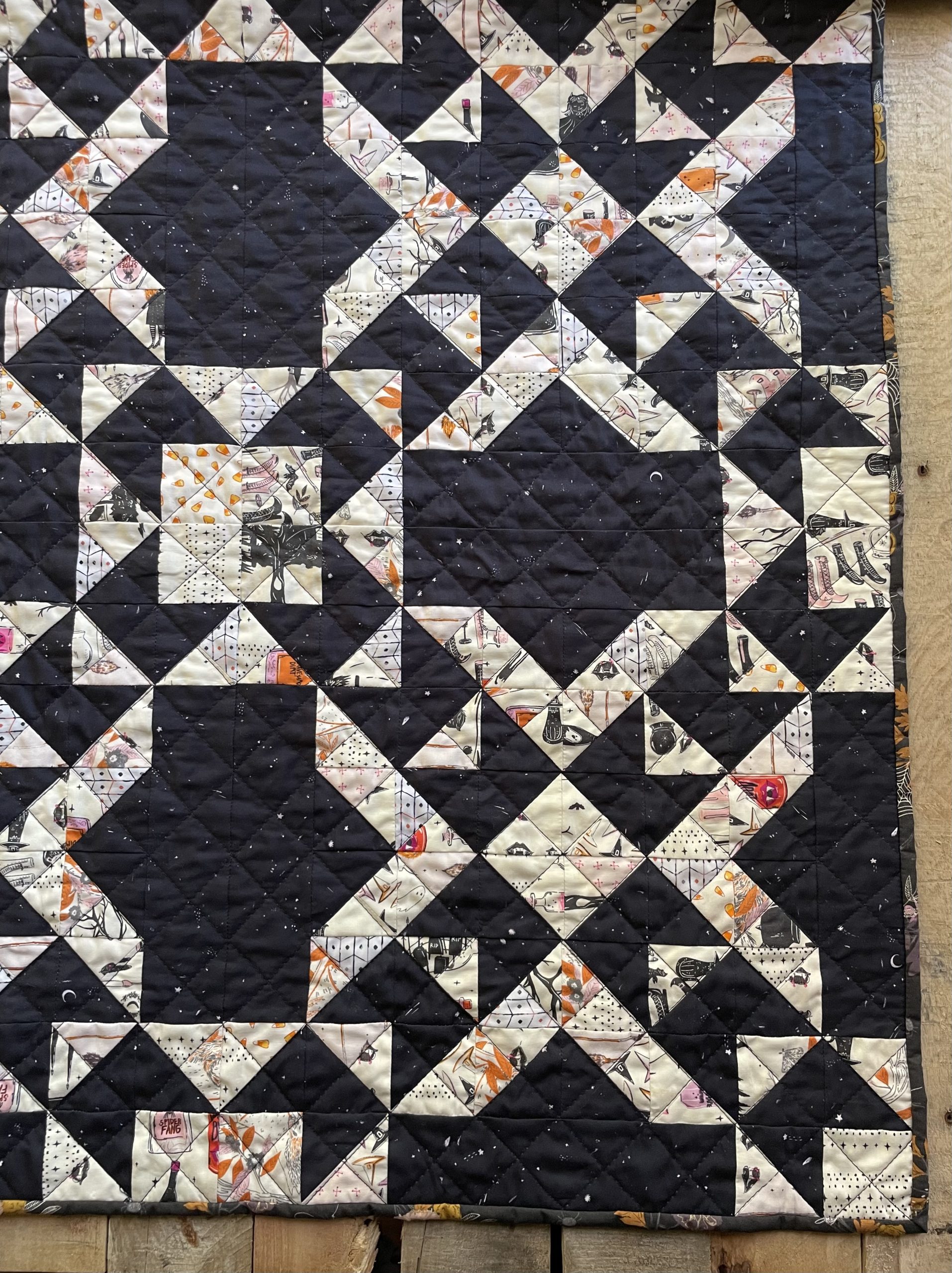 Geometric patterned quilt with dark and light fabric.