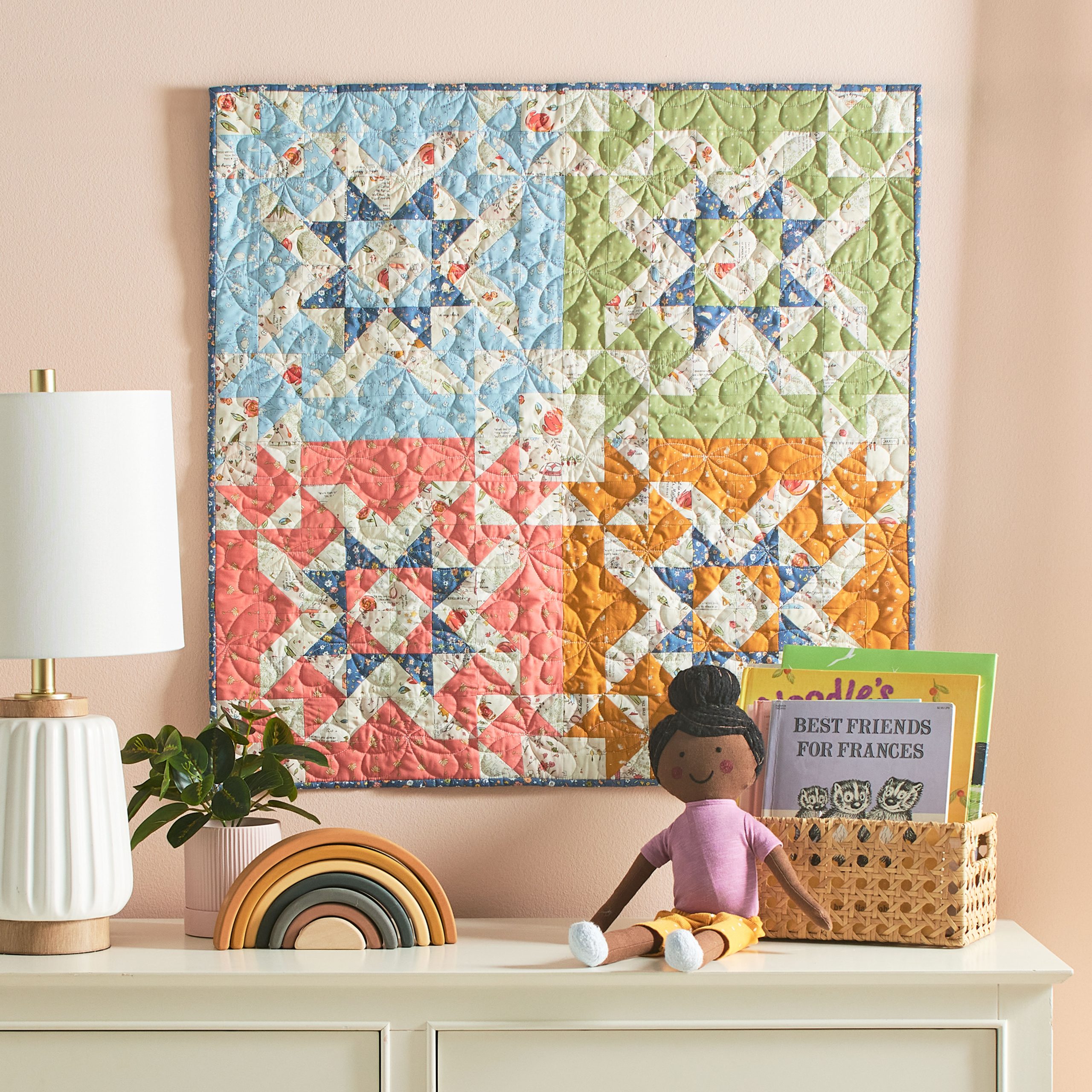 Colorful quilt with star pattern above dresser.