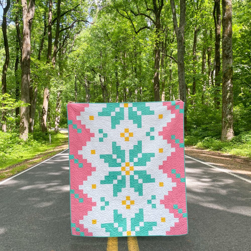 Colorful quilt displayed on road in forest