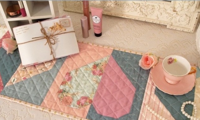 Pastel quilted table runner with tea and envelope
