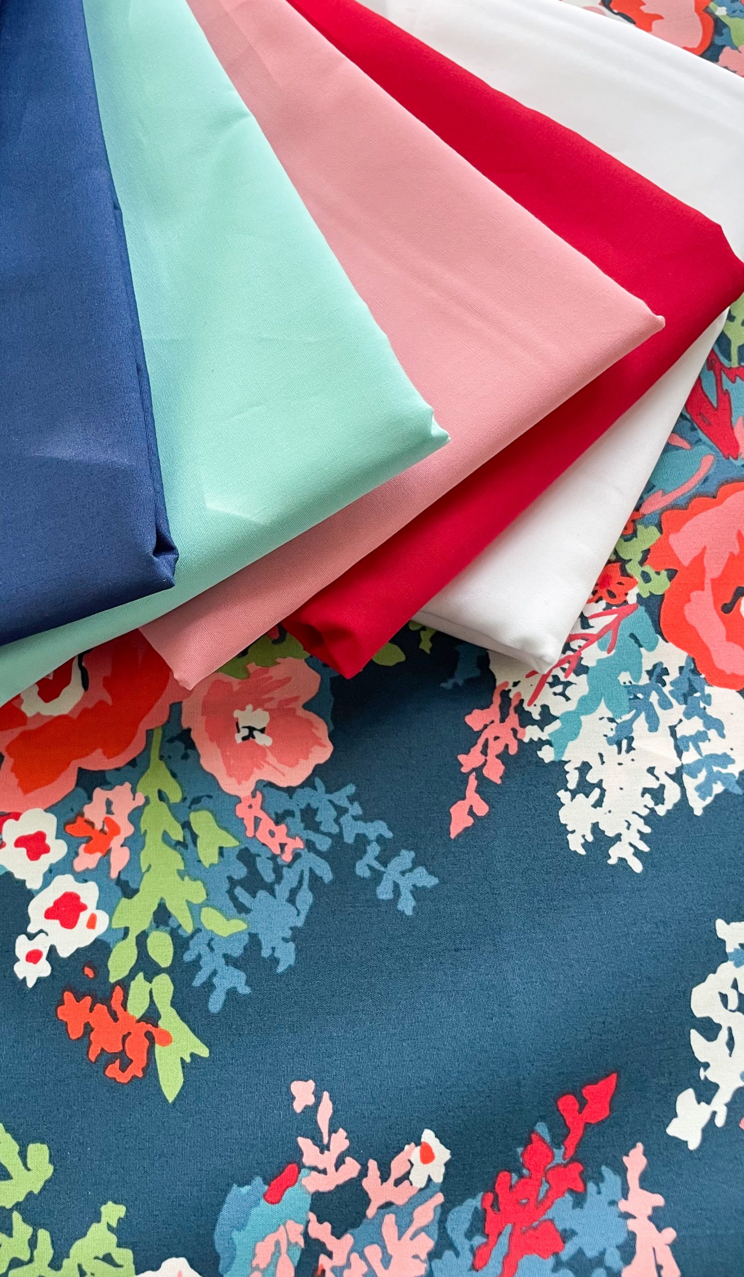 Colorful folded fabrics on floral patterned background