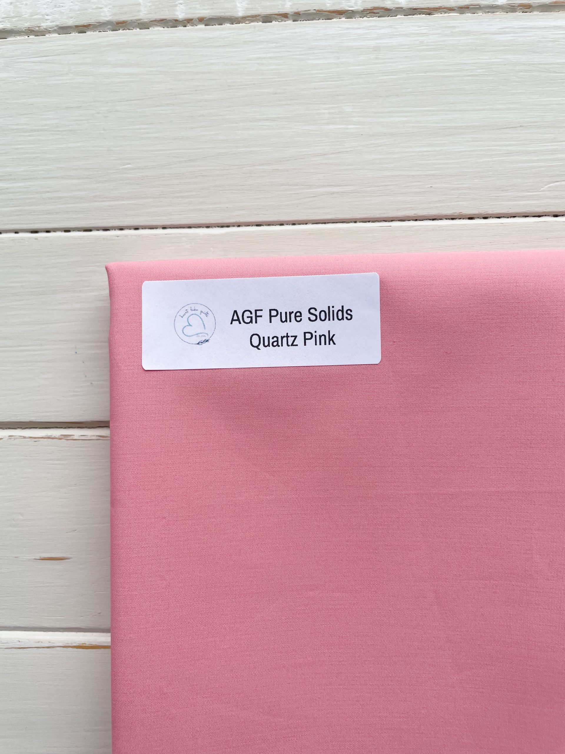 Pink fabric labeled AGF Pure Solids
