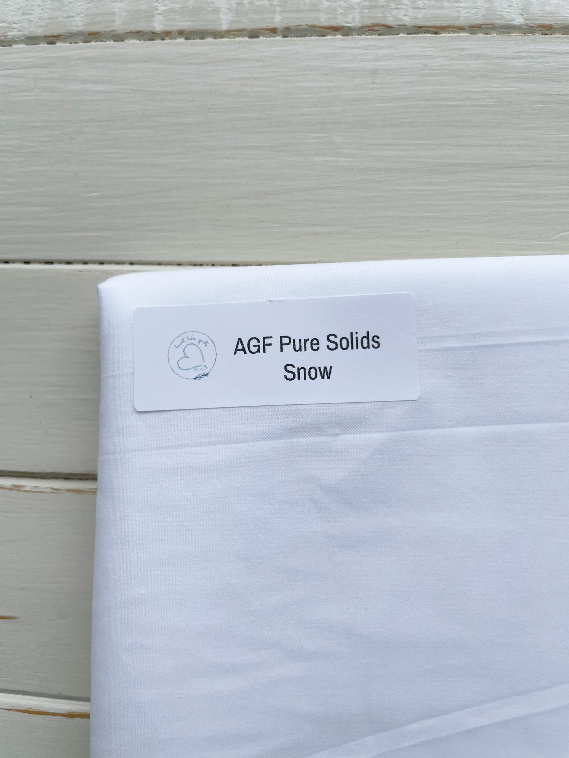 White fabric labeled AGF Pure Solids Snow