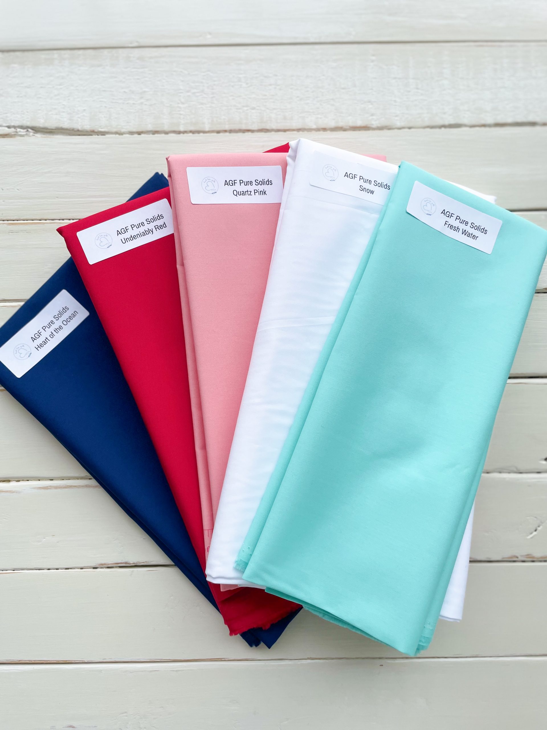 Colorful fabric rolls on wooden surface