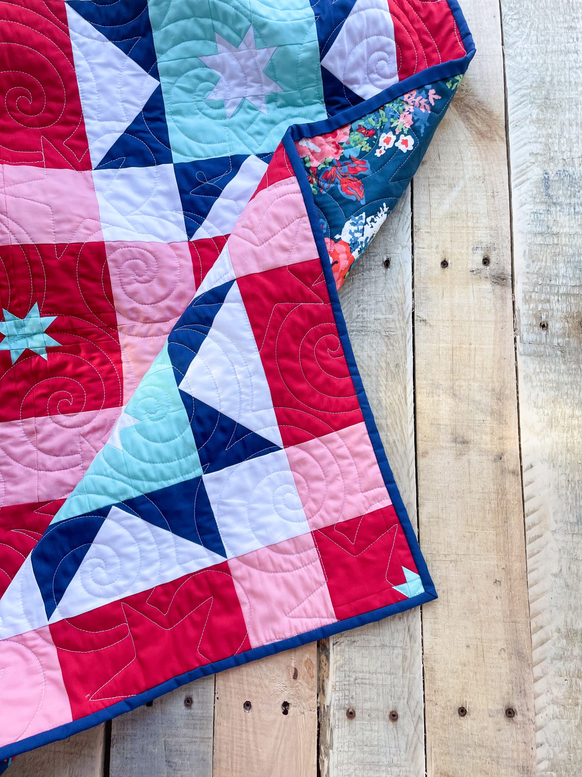 Colorful quilt with geometric patterns on wood.