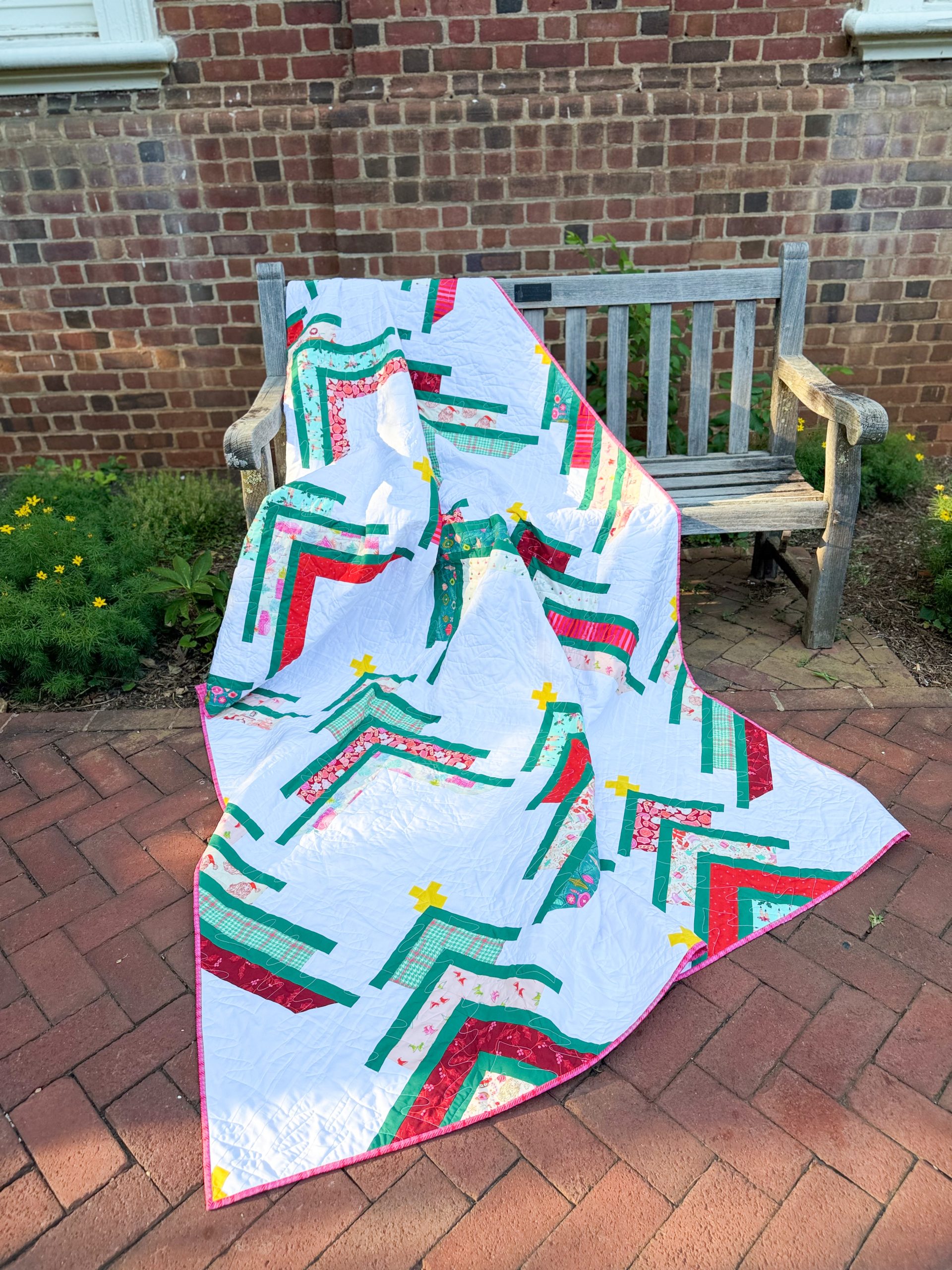 Colorful patchwork quilt draped over wooden bench outdoors