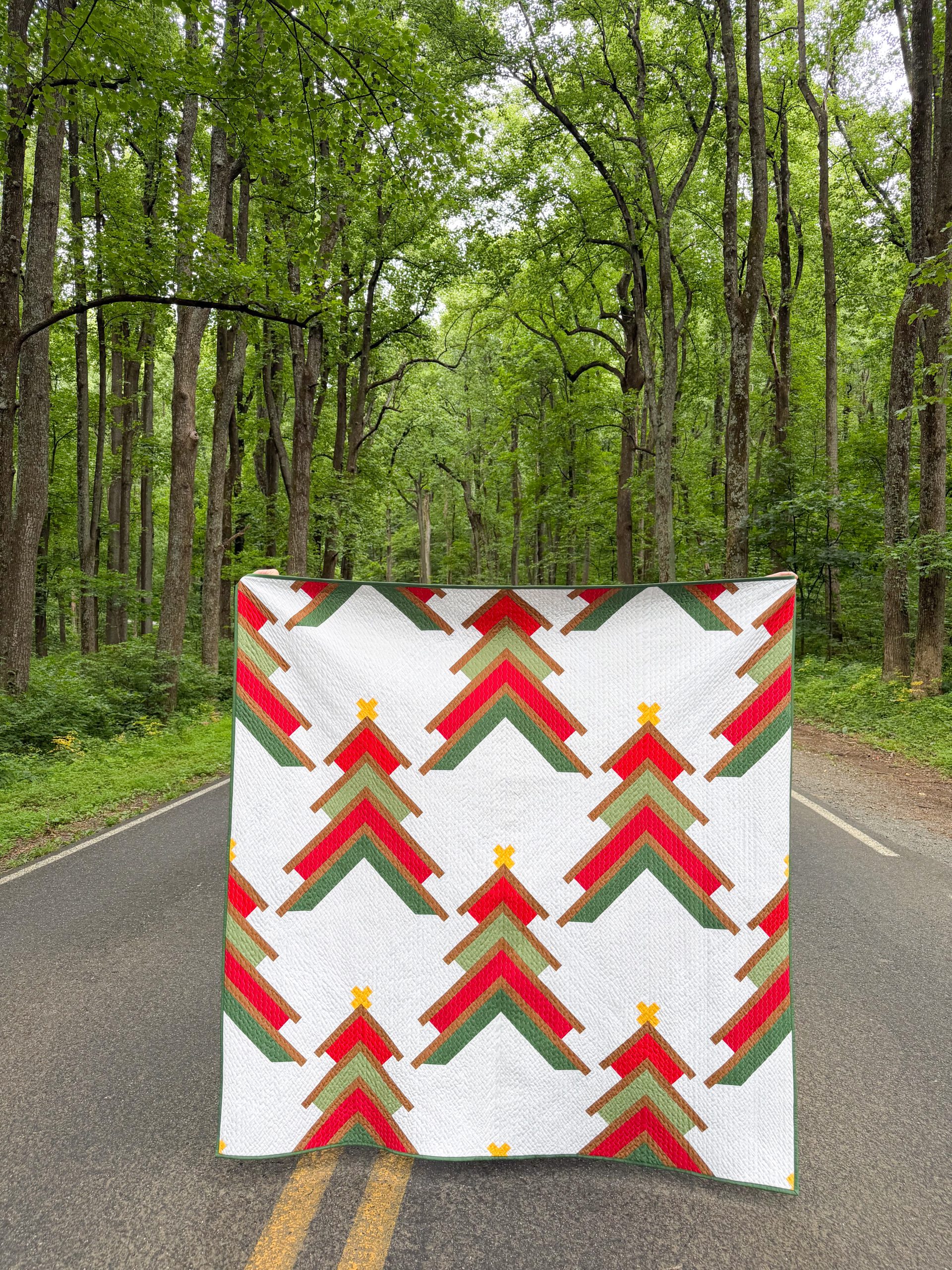 Colorful geometric quilt held on forest road