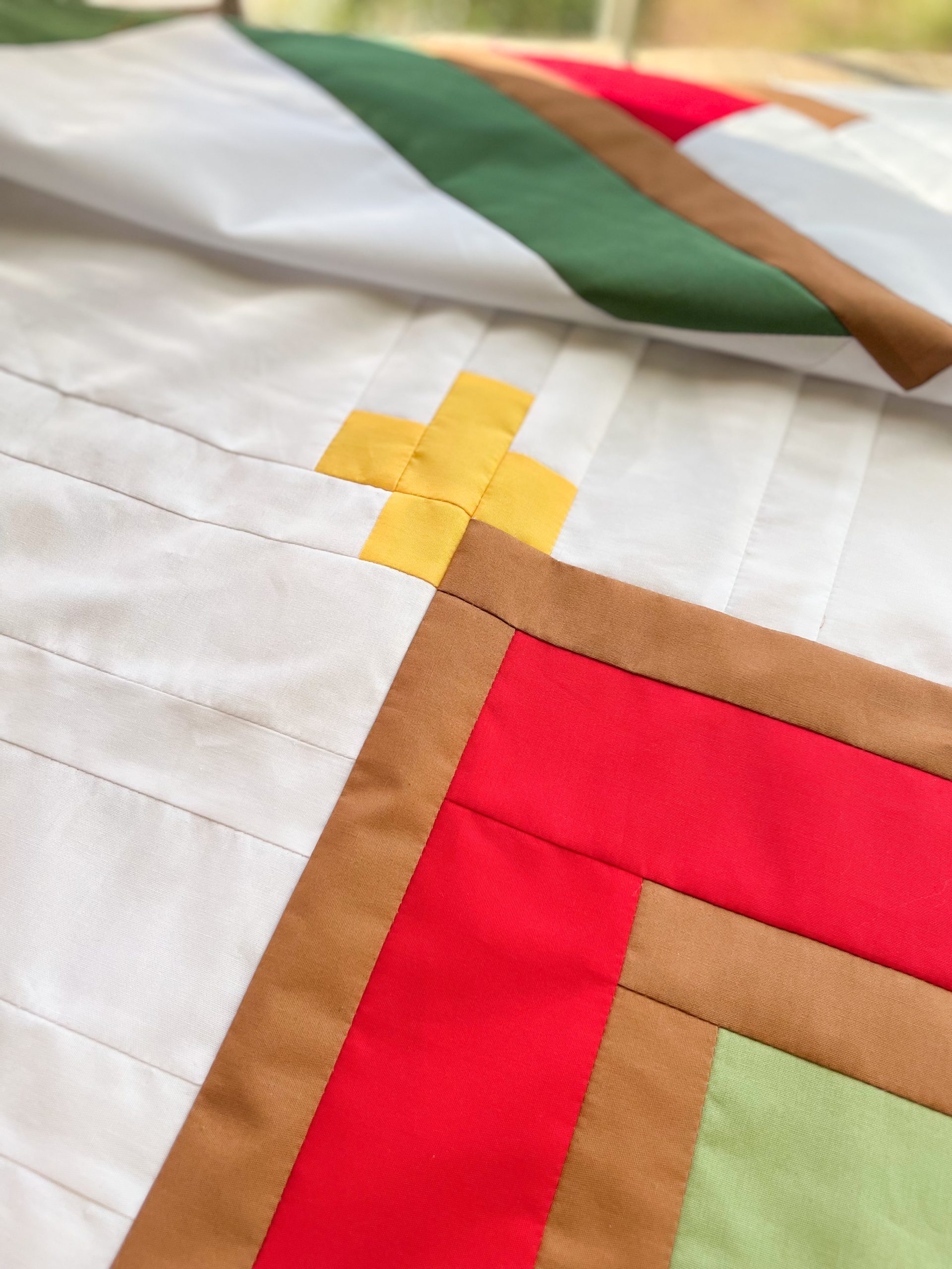 Colorful geometric patchwork quilt with yellow cross