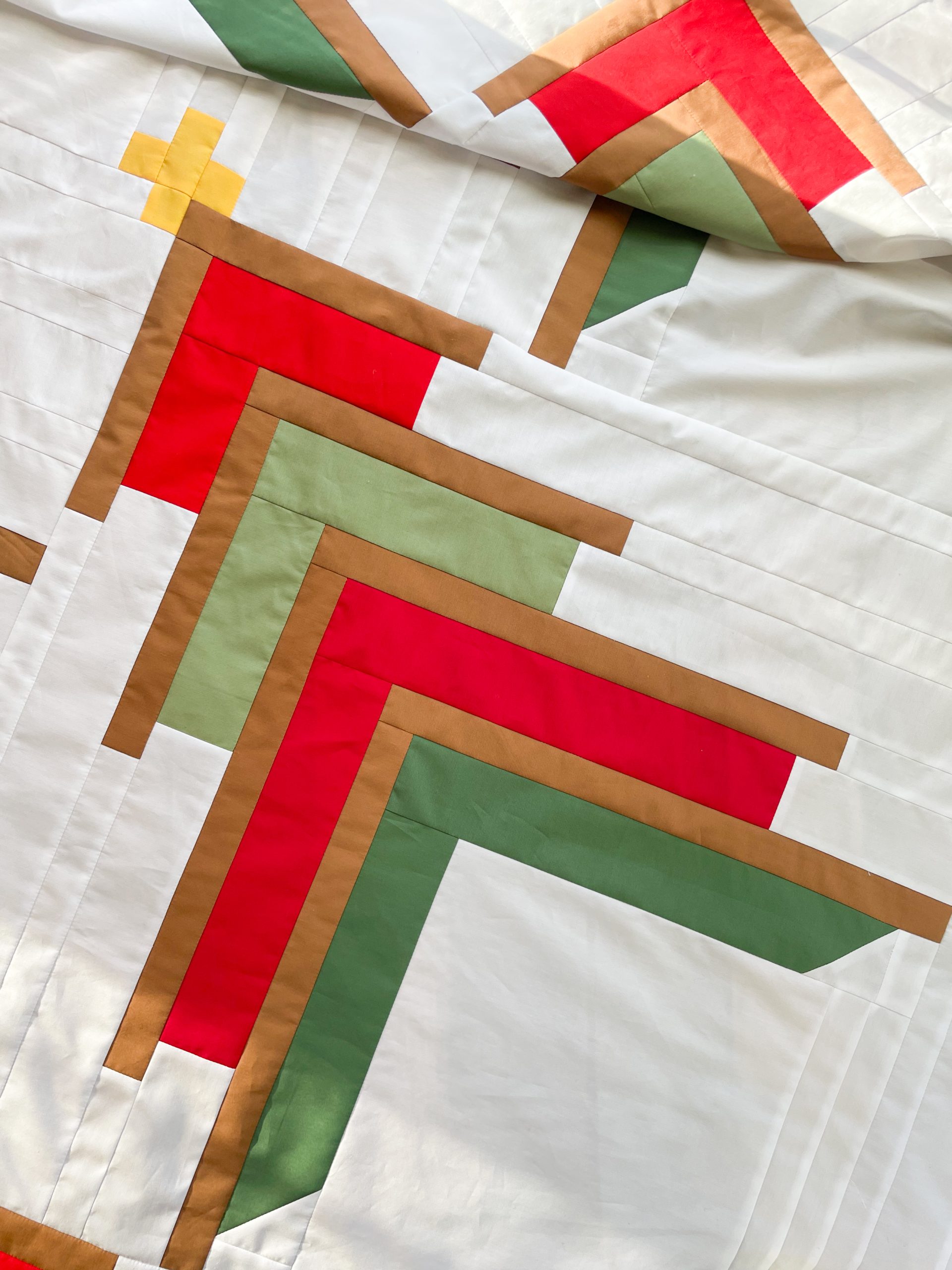 Geometric quilt with red, green, and tan strips