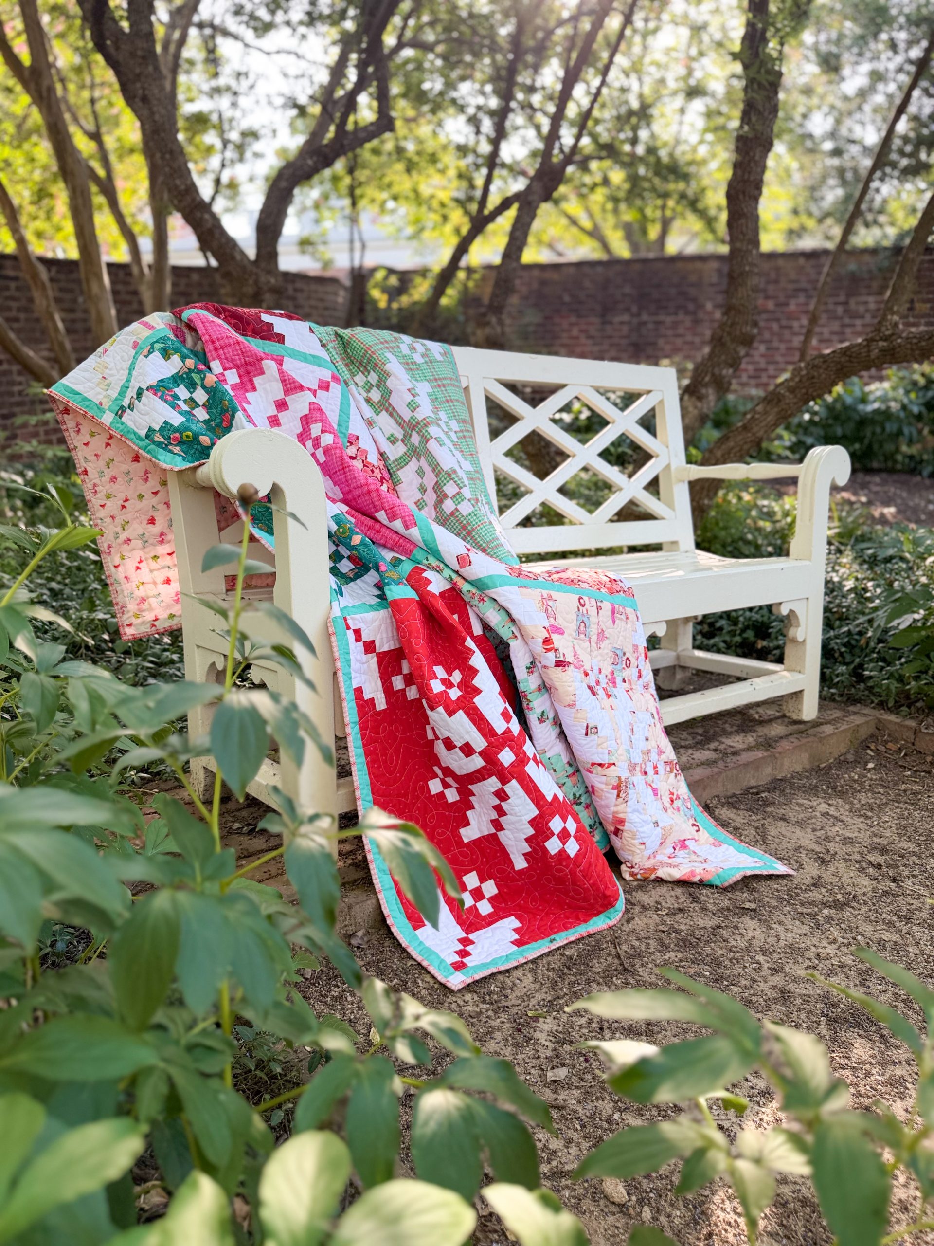 Colorful patchwork quilt draped over white garden bench