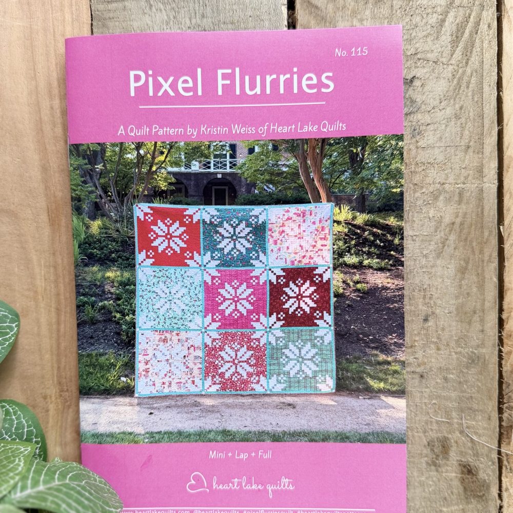 Pixel Flurries quilt pattern cover on wooden fence