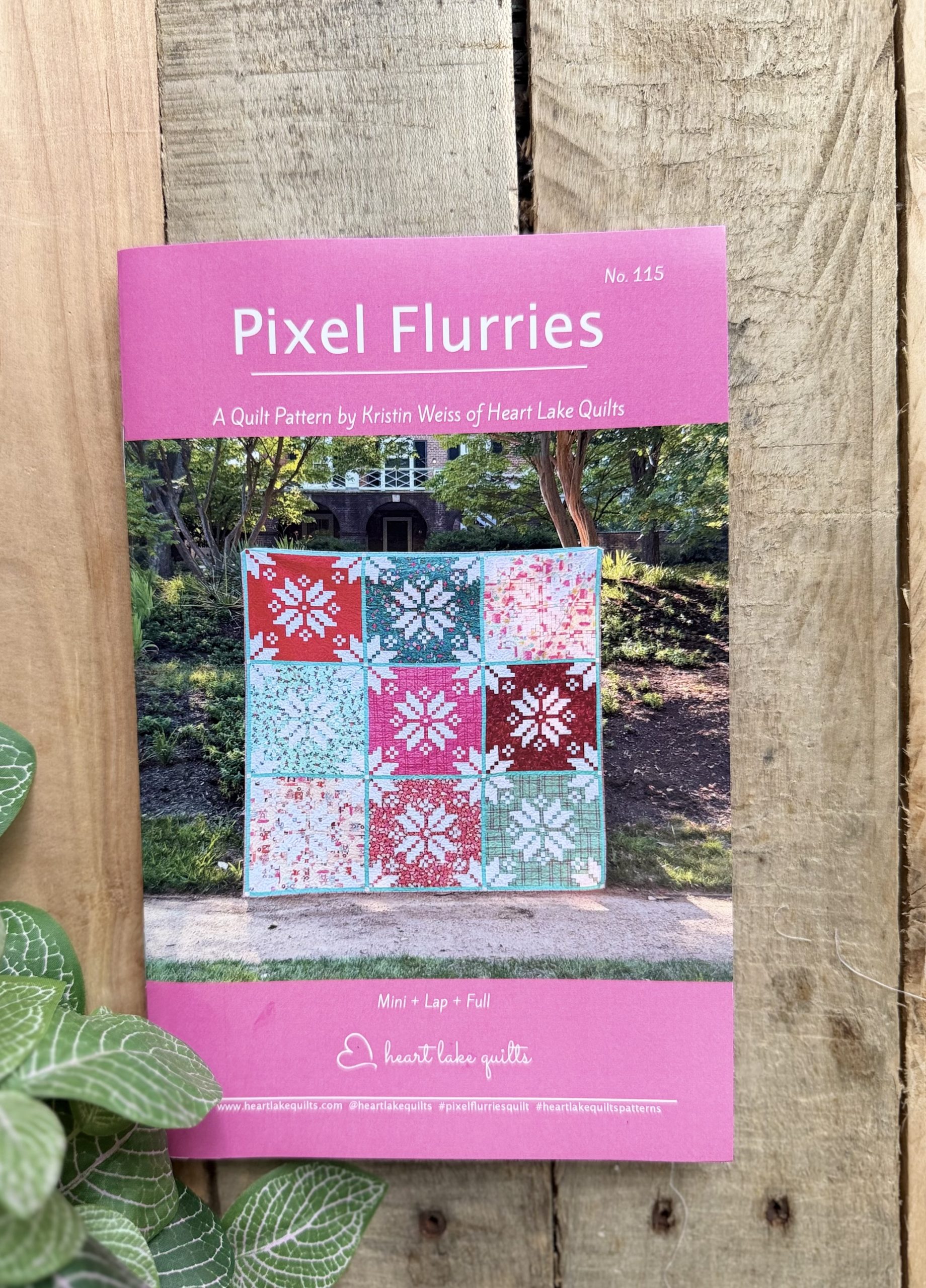 Pixel Flurries quilt pattern cover on wooden fence