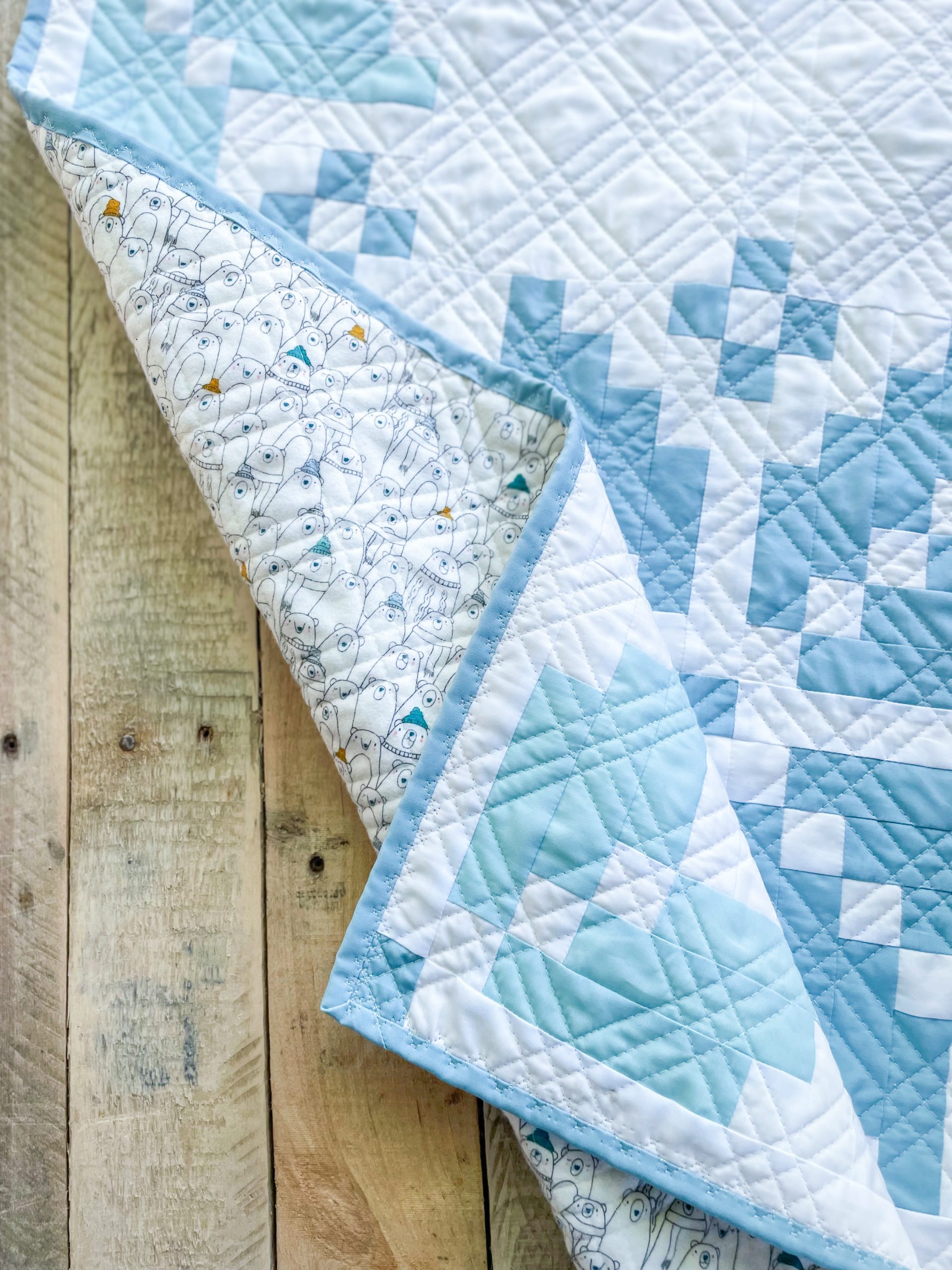 Blue and white patchwork quilt with polar bear backing