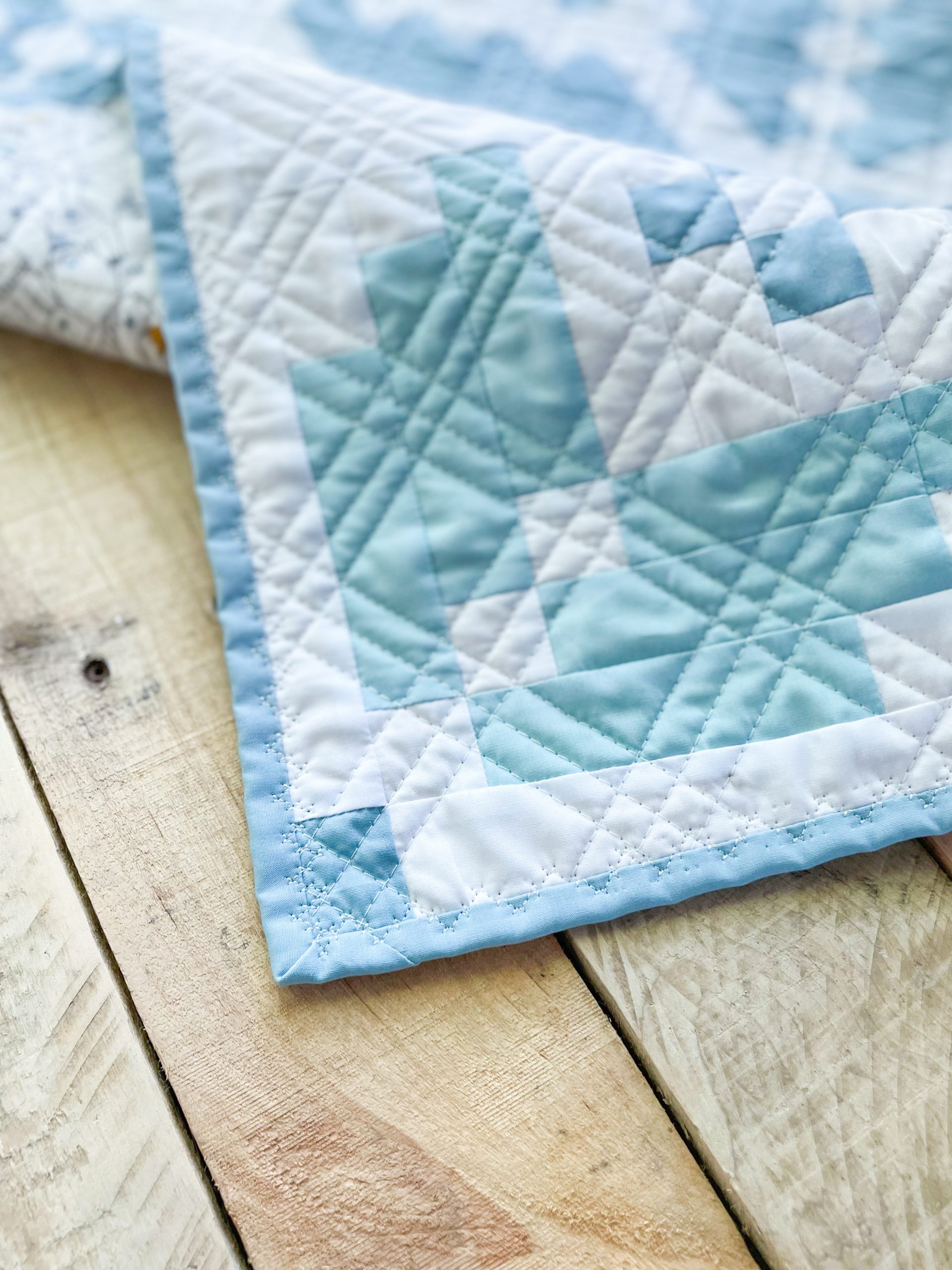 Blue and white geometric quilt on wooden table