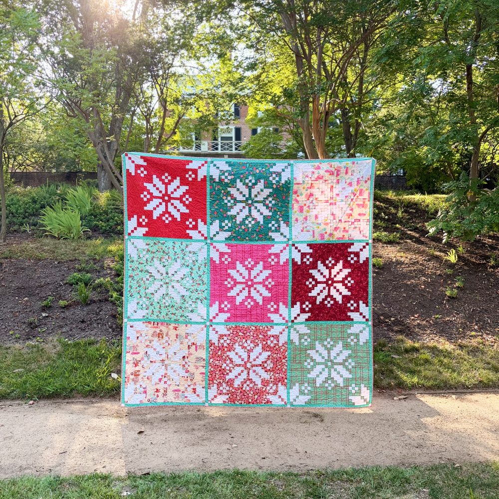 Colorful patchwork quilt displayed in sunny garden