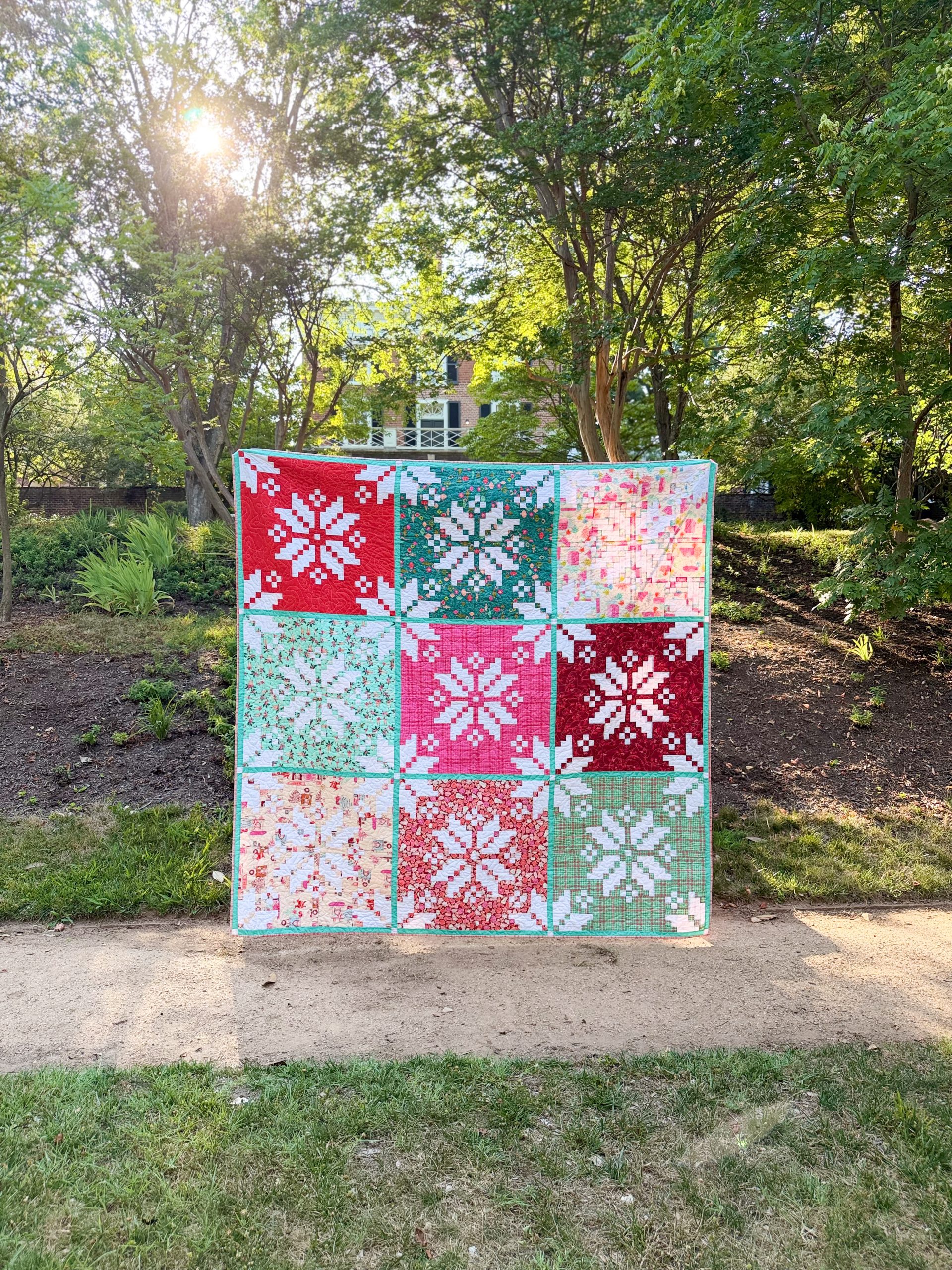 Colorful patchwork quilt displayed in sunny garden