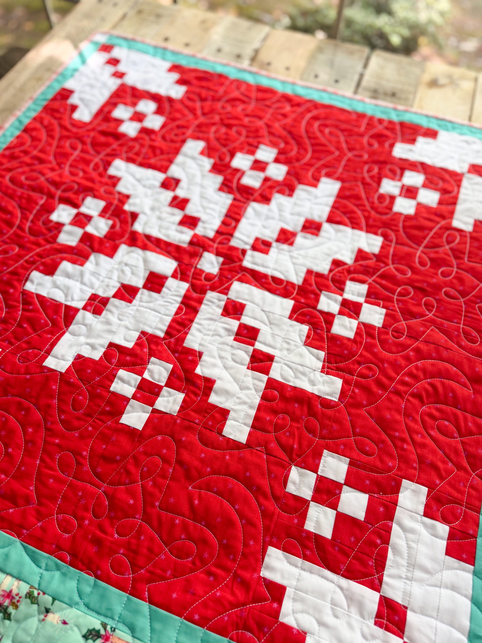Red and white patchwork quilt with stitched pattern